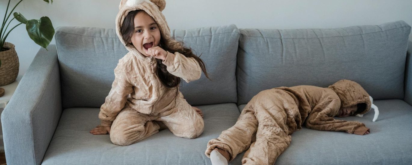 kids wearing pyjamas playing on sofa