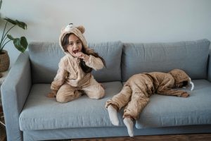 kids wearing pyjamas playing on sofa