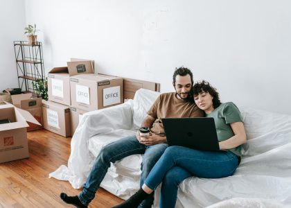 couple sitting on a couch browsing on computer